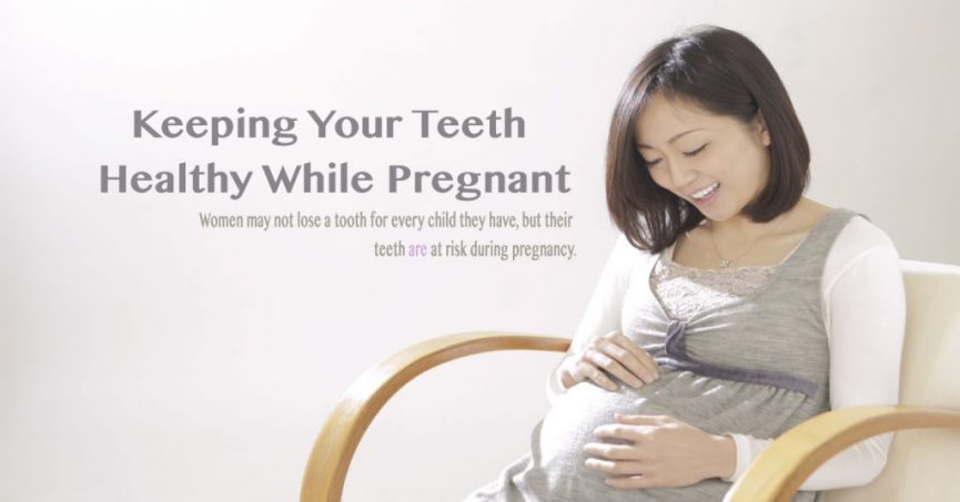 a pregnant woman sitting in a chair, smiling and looking down at her belly with her hands resting on it. She is wearing a light gray dress with a white shirt underneath. The background is plain and bright. The text overlay reads, "Keeping Your Teeth Healthy While Pregnant," followed by a smaller subtext: "Women may not lose a tooth for every child they have, but their teeth are at risk during pregnancy."